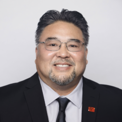 headshot of Dean Nakanishi in a suit and tie